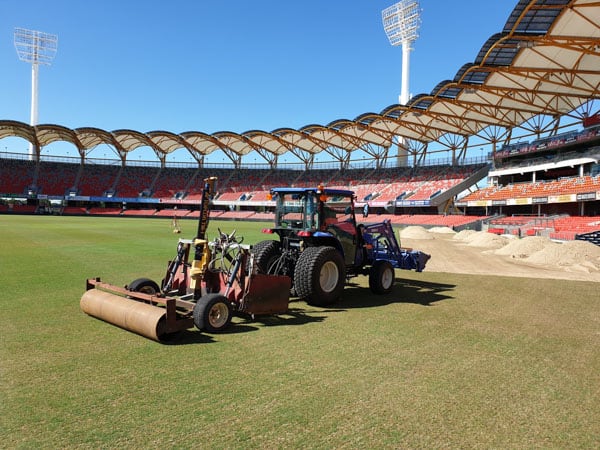 Turf levelling grader and roller at a large sports stadium